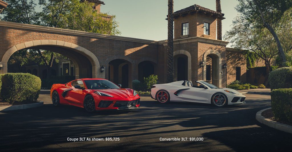 A white and red 2025 Chevy Corvette Stingray parked in the driveway of a modern home, highlighting its bold design.